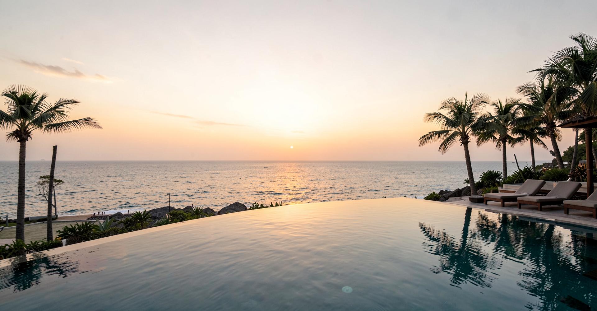 Resort infinity pool overlooking the ocean at sunset